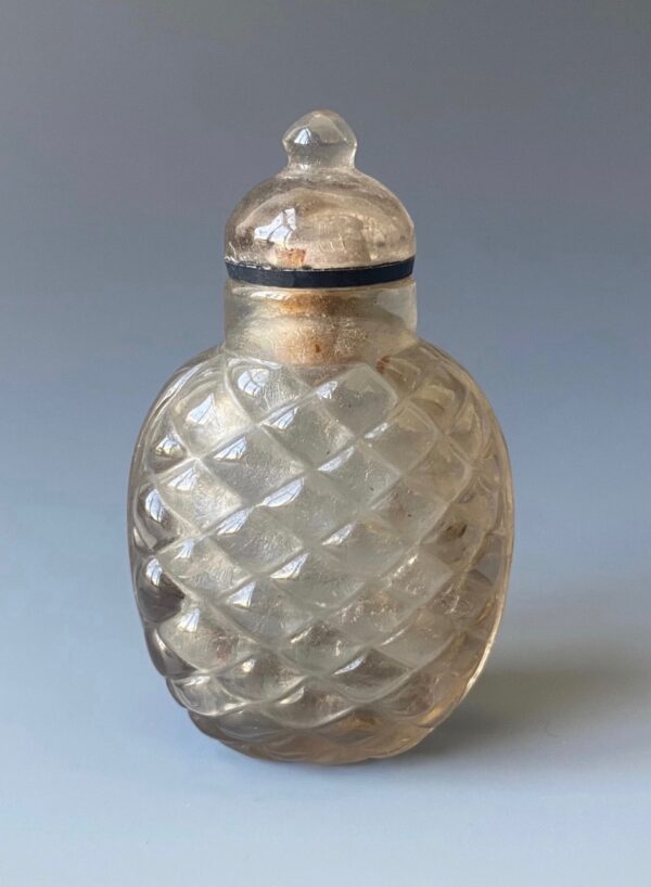 Antique Chinese snuff bottle of quartz crystal. Carved with a raised diamond pattern. With original quartz lid.
